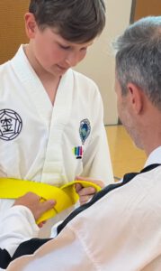 Junge erhält gelben Gürtel